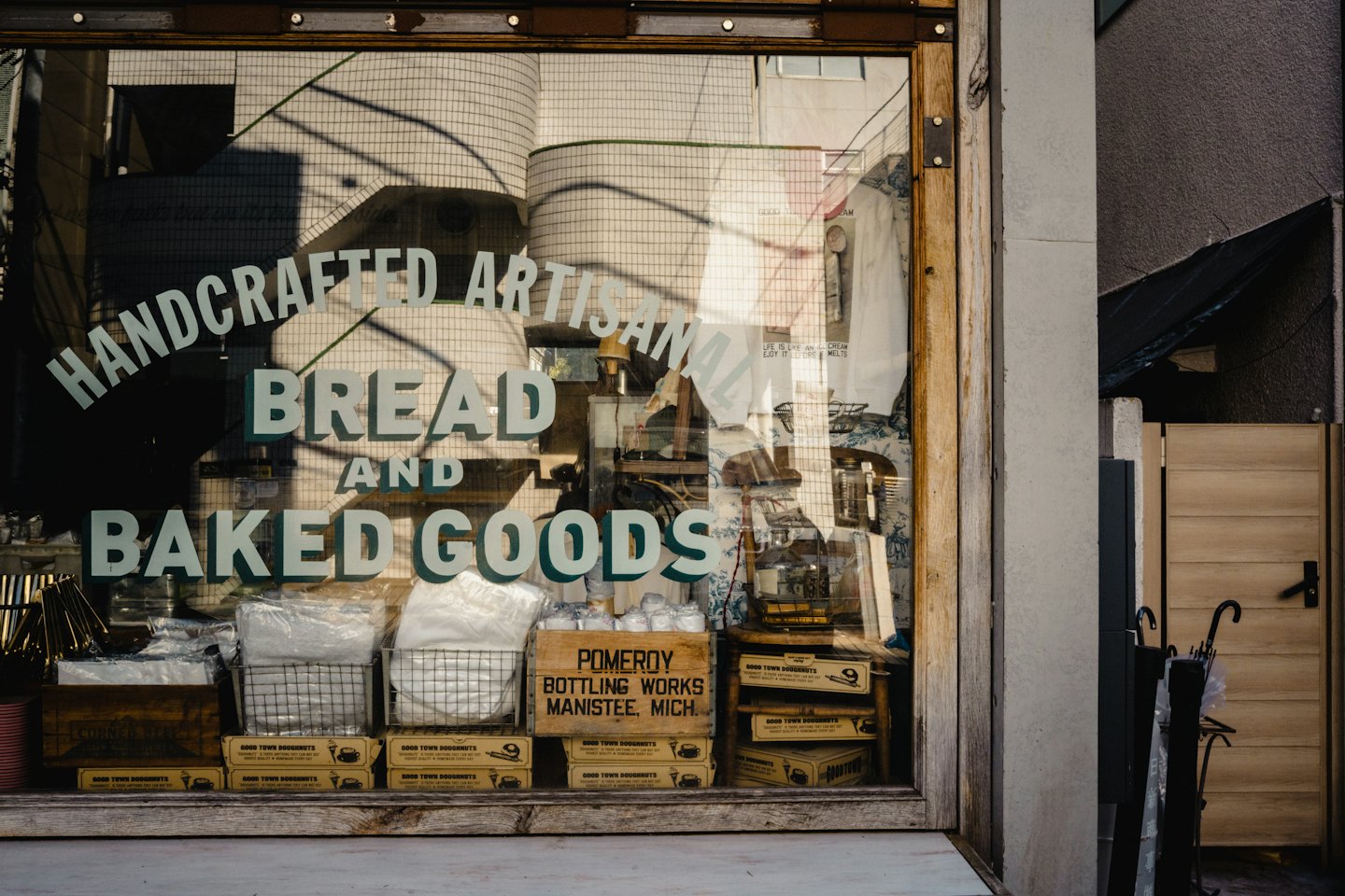 Rustic bakery window displays artisanal bread and doughnut packages.