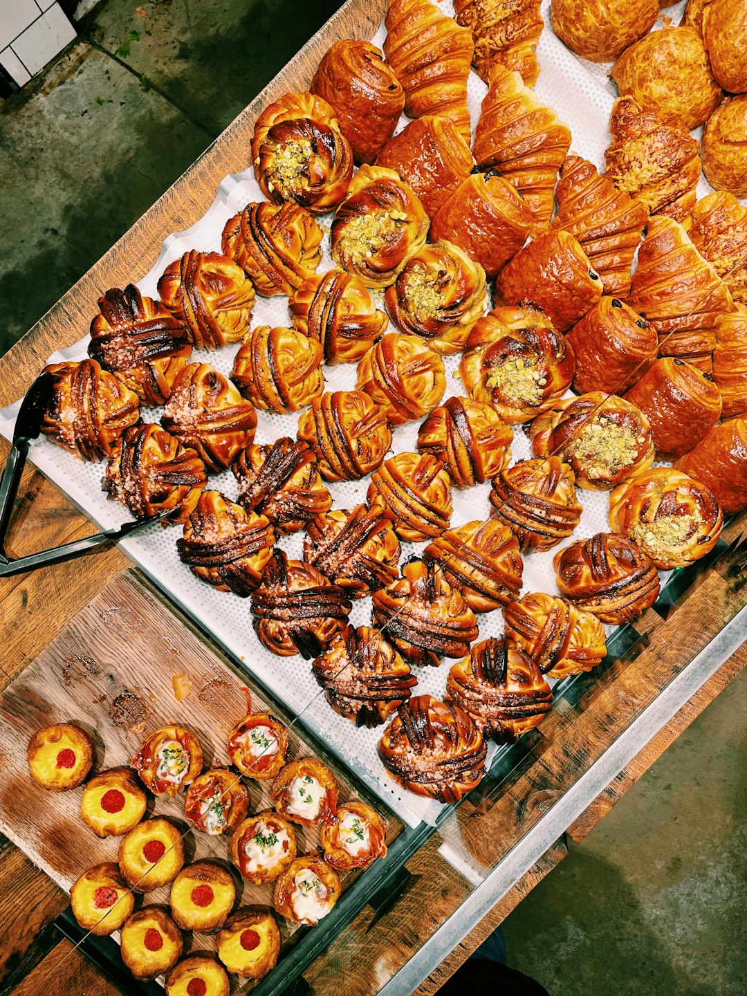 Freshly baked pastries are arranged in a bakery display case.